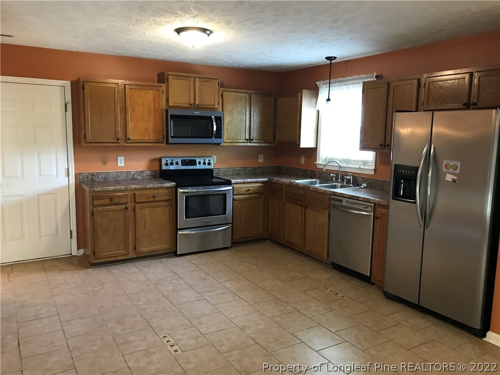 713 Rim Road Fayetteville, NC 28314 - Photo 2 of 16 a kitchen with stainless steel appliances granite countertop a stove a sink dishwasher a refrigerator and a microwave
