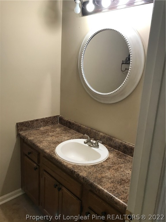 713 Rim Road Fayetteville, NC 28314 - Photo 7 of 16 a bathroom with a granite countertop sink and a mirror