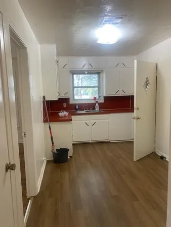 a view of a kitchen with a sink wooden floor and window