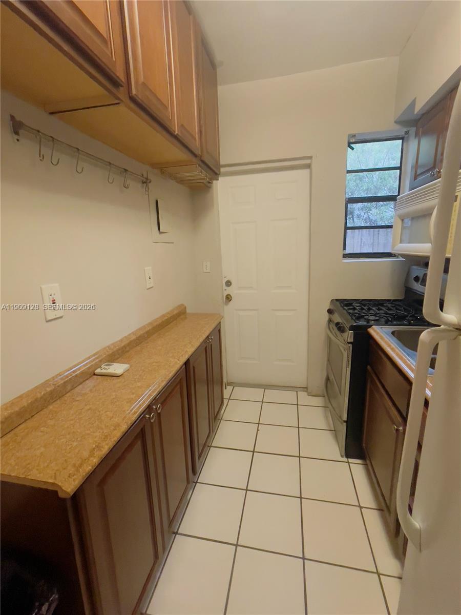 807 86th Street, Unit 805 Miami Beach, FL 33141 - Photo 5 of 10 a kitchen with a sink a stove top oven and cabinets