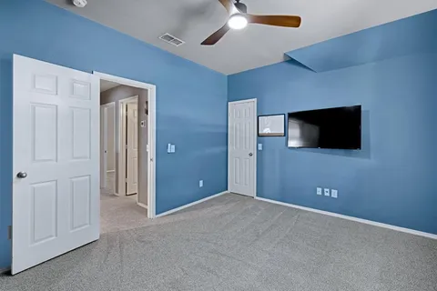 a view of a livingroom with an empty space and a ceiling fan