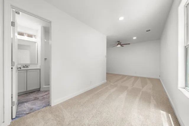 an empty room with a bathroom and a sink