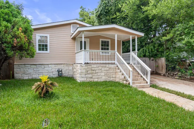 a view of a house with a yard and sitting area