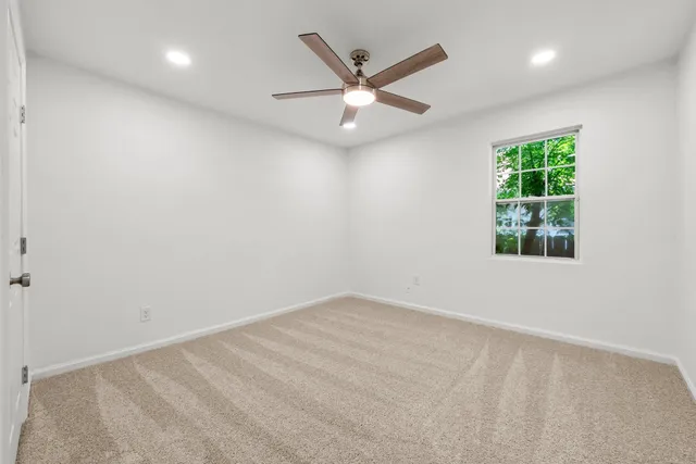 an empty room with a window and a ceiling fan