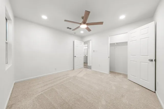 an empty room with closet and fan