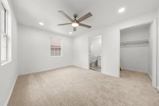 an empty room with closet and windows