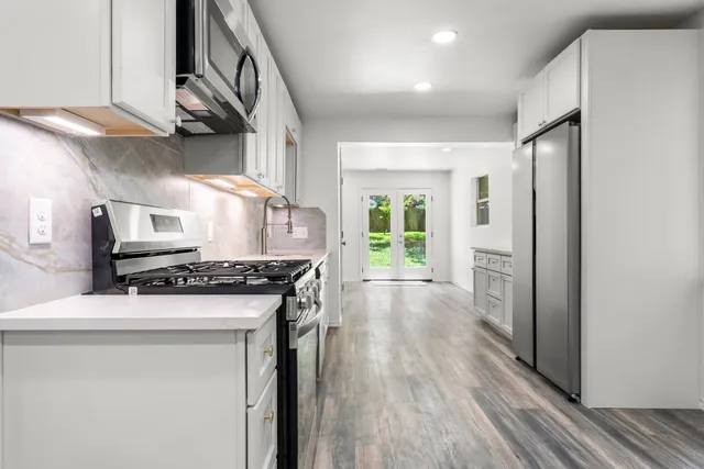 a kitchen with stainless steel appliances granite countertop a stove and a refrigerator