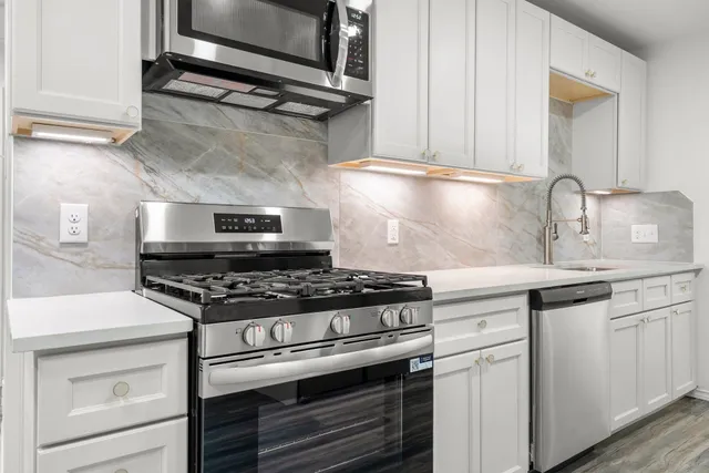 a stove top oven sitting inside of a kitchen