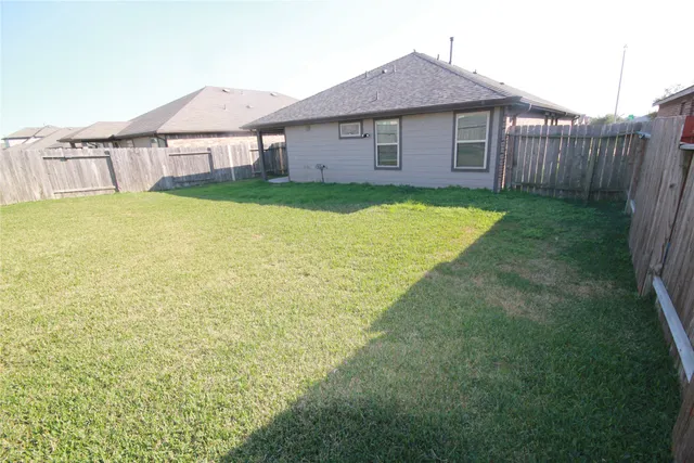 a view of a house with a yard and a fence