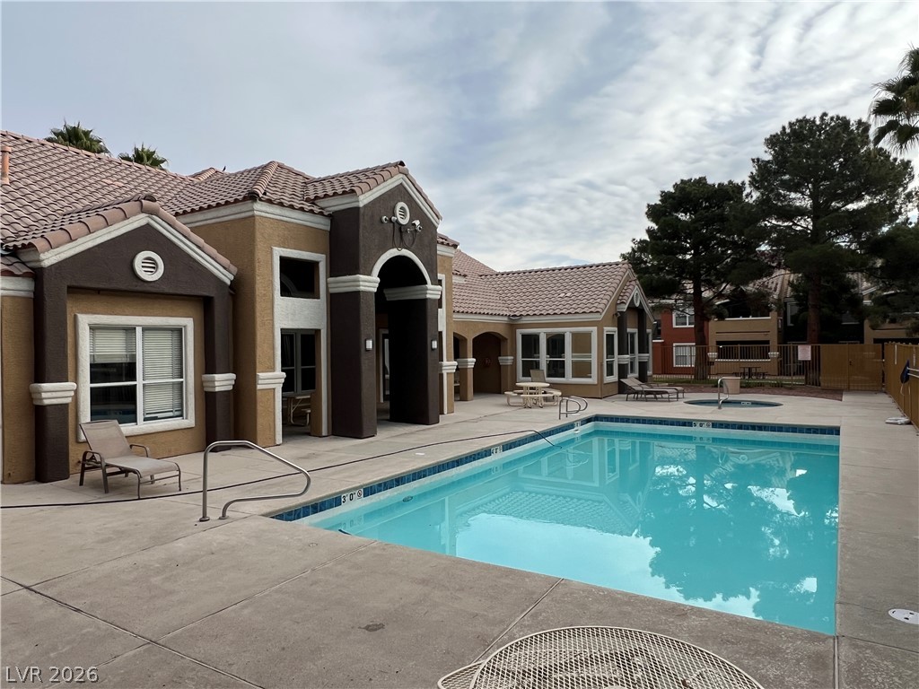8101 West Flamingo Road, Unit 2161 Las Vegas, NV 89147 - Photo 2 of 15 A well-maintained pool and spa offer a refreshing oasis amidst a charming architectural backdrop.