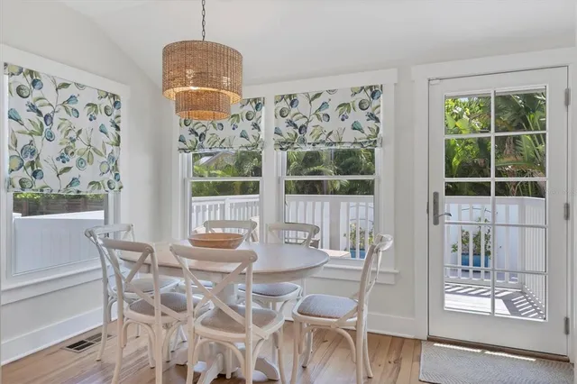 a dining room with wooden floor and a chandelier