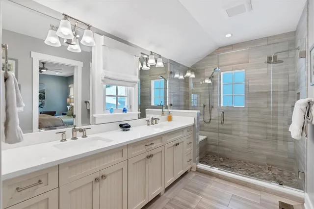 a bathroom with a double vanity sink mirror and shower