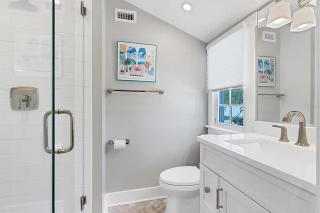 a bathroom with a sink mirror vanity and toilet