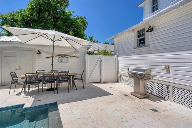 a view of a patio with table and chairs under an umbrella
