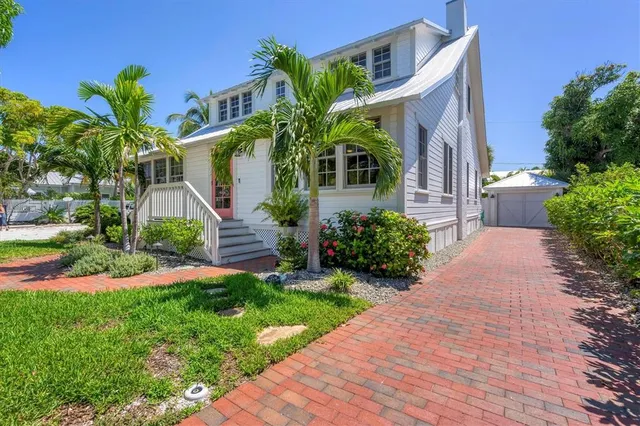 a front view of a house with a yard and potted plants