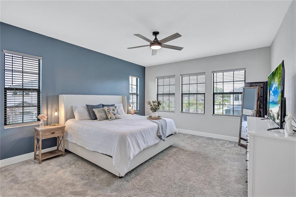 4593 Shoreleaf Loop Valrico, FL 33596 - Photo 11 of 39 a spacious bedroom with a bed a window and a flat screen television