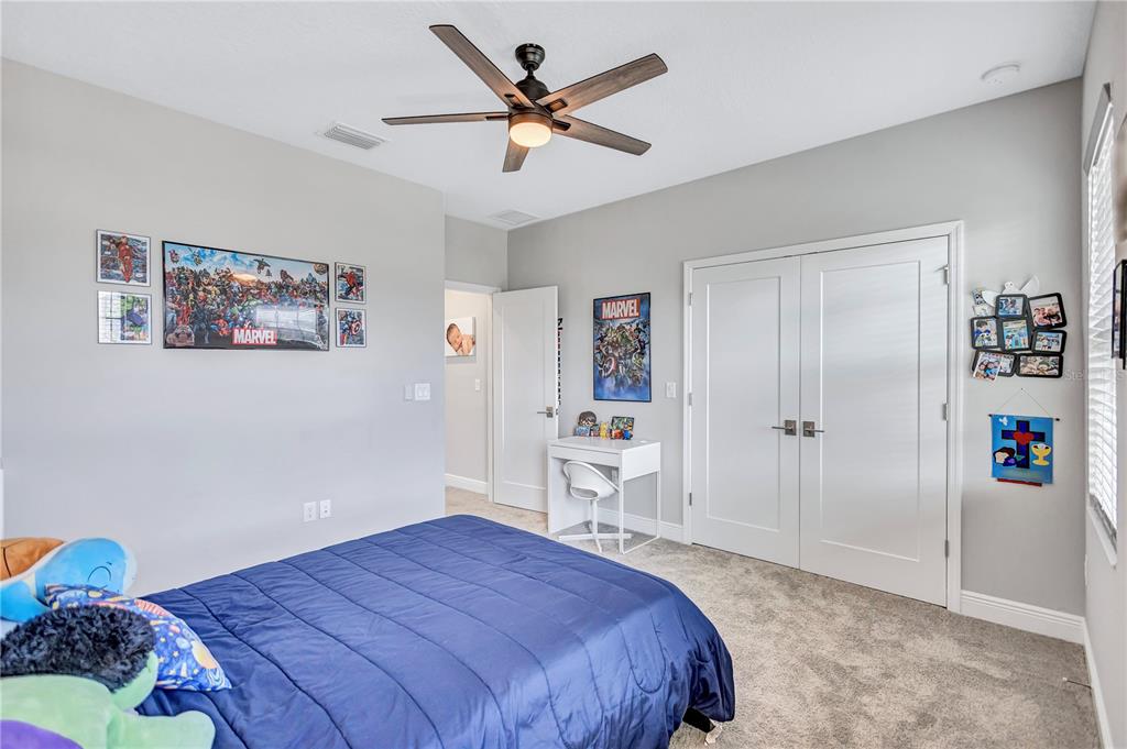 4593 Shoreleaf Loop Valrico, FL 33596 - Photo 25 of 39 a bedroom with a large bed and a chandelier