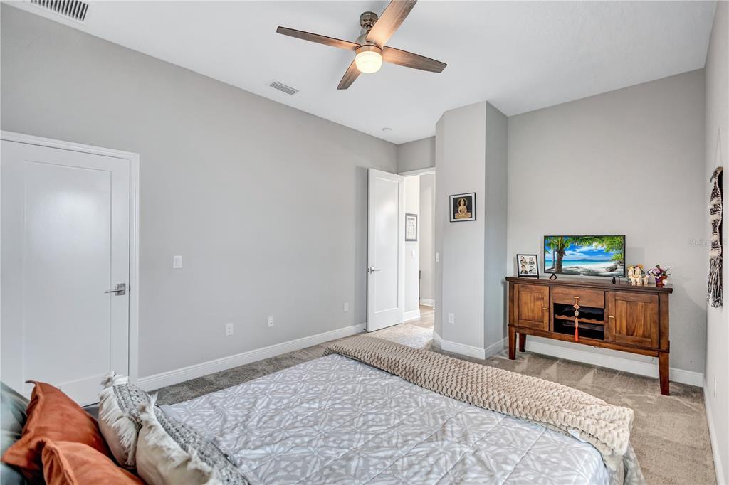 4593 Shoreleaf Loop Valrico, FL 33596 - Photo 29 of 39 a bedroom with a bed and a chandelier