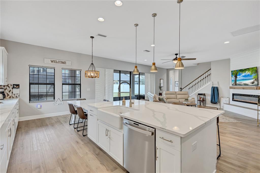4593 Shoreleaf Loop Valrico, FL 33596 - Photo 10 of 39 a large kitchen with kitchen island a island a sink a stove and wooden floor