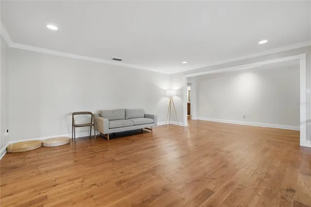 a view of a livingroom with wooden floor and a chandelier