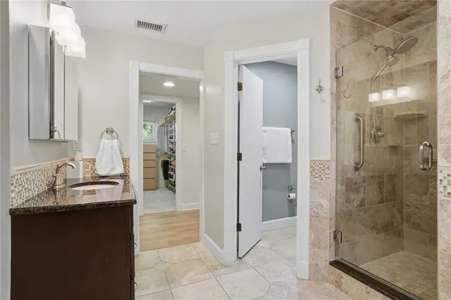 a spacious bedroom with a large bed a chandelier and a window