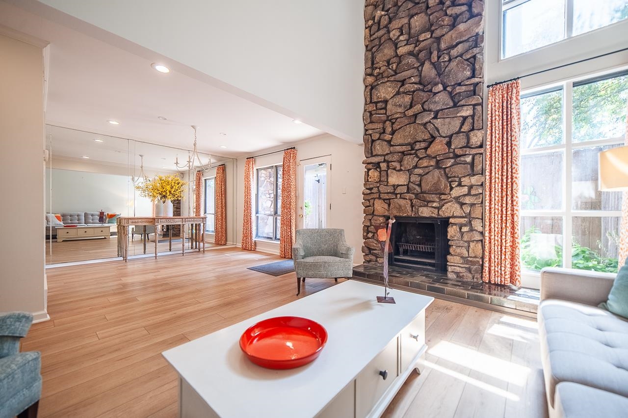 a living room with furniture a fireplace and a large window