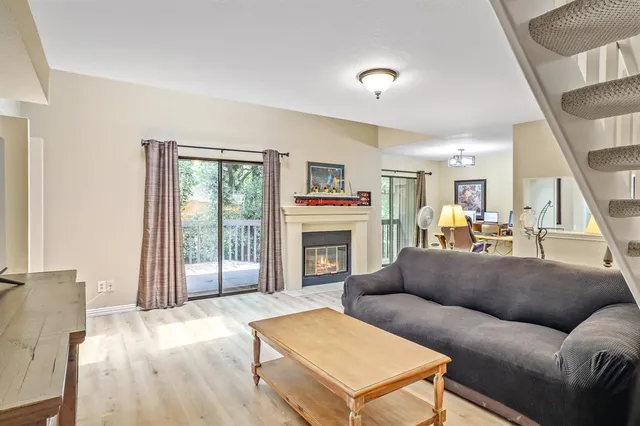 a living room with furniture a fireplace and a large window