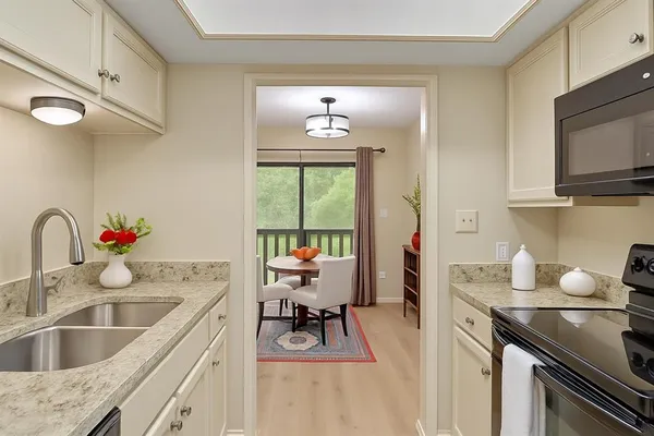 a kitchen with a sink stove top oven and microwave