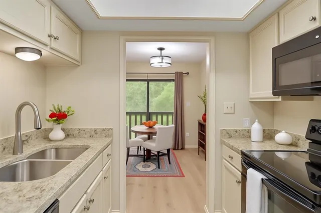 a kitchen with a sink stove top oven and microwave