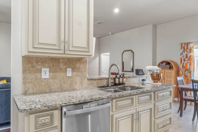 a kitchen with granite countertop white cabinets and appliances