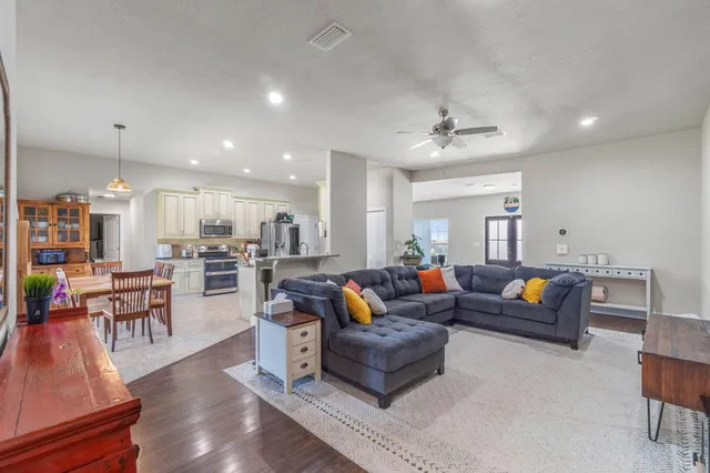 a living room with furniture kitchen view and a chandelier