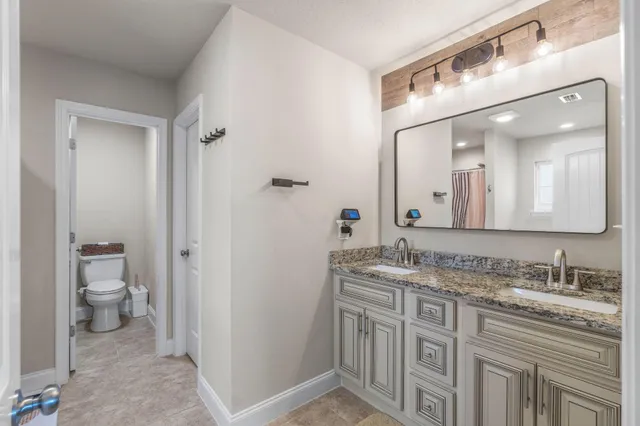 a spacious bathroom with a granite countertop sink and a mirror