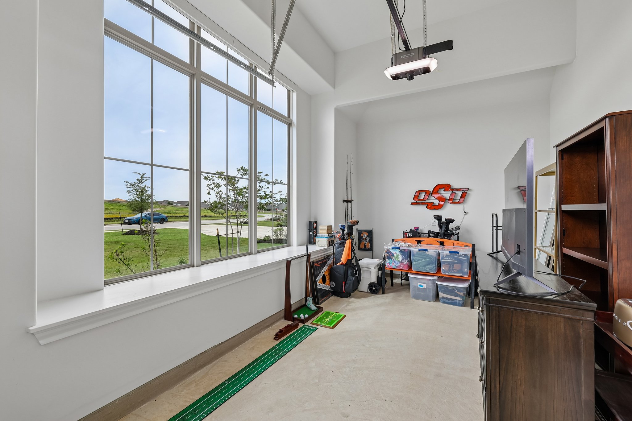 130 Firethorn Loop Bastrop, TX 78602 - Photo 25 of 38 Garage featuring an expansive window, high ceilings, and a concrete floor