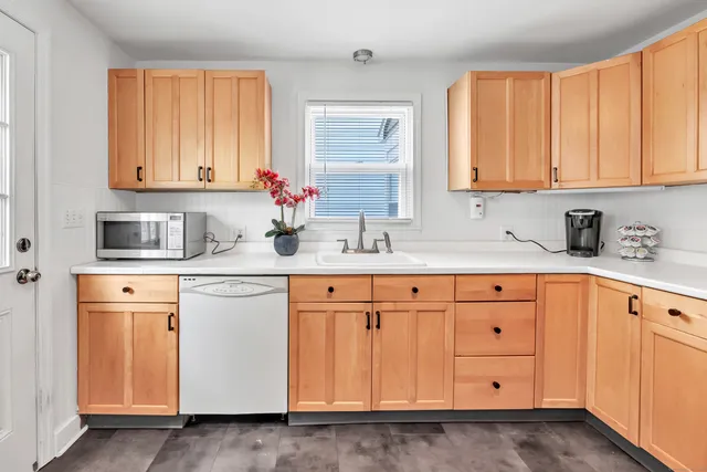 a kitchen with granite countertop white cabinets sink and dishwasher