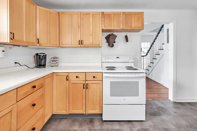 a kitchen with granite countertop white cabinets and white appliances