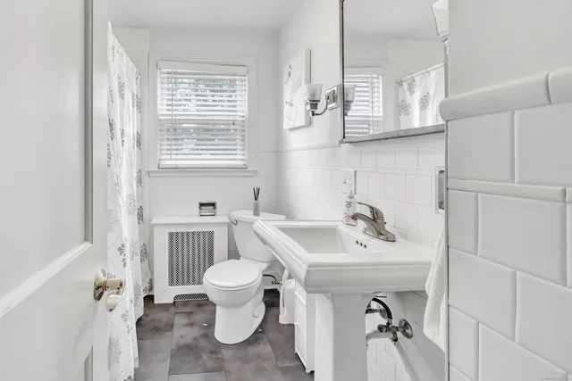 a bathroom with a sink toilet and a mirror