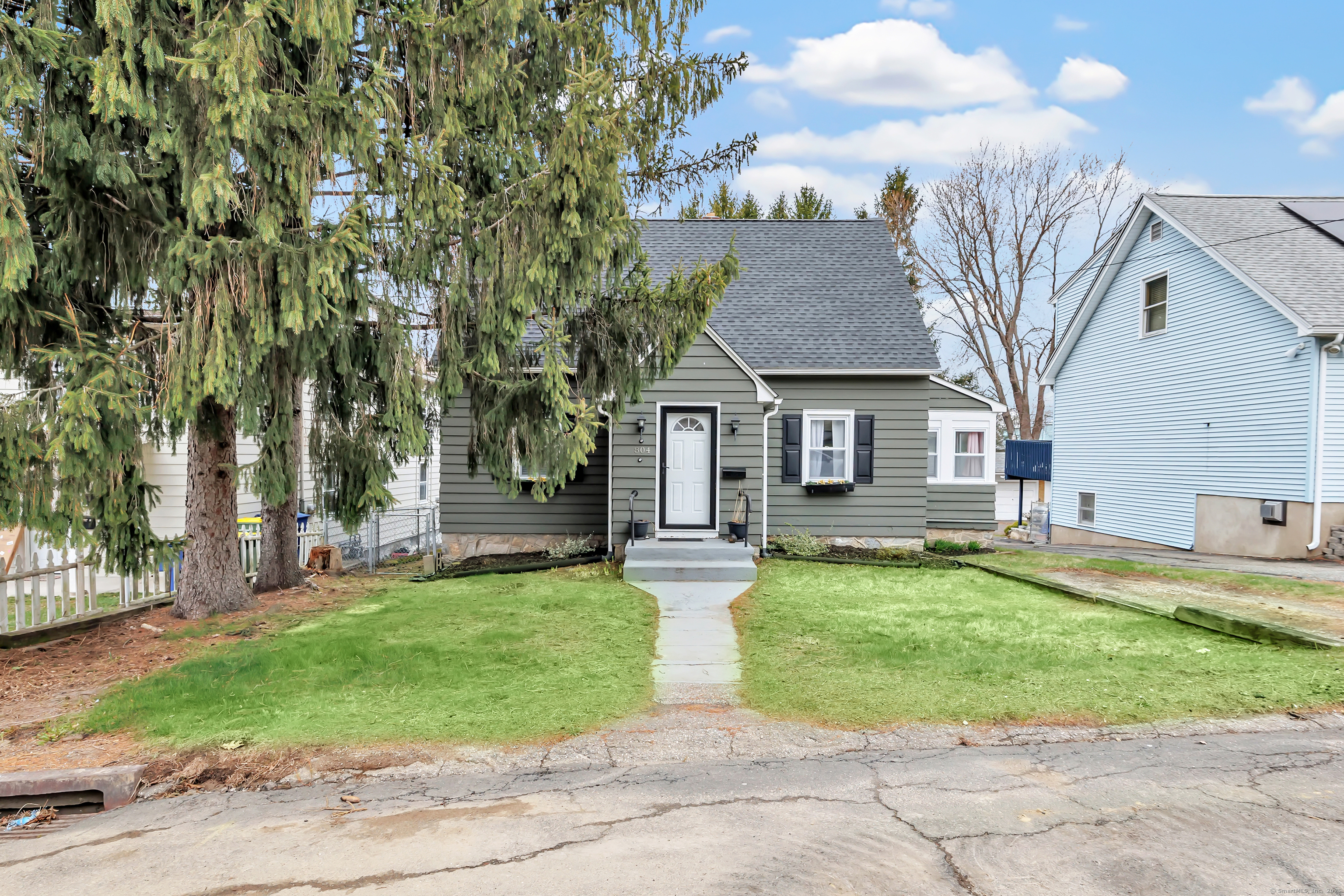 804 Washington Ave Extension Waterbury, CT 06708 - Photo 2 of 35 a front view of a house with a garden and trees