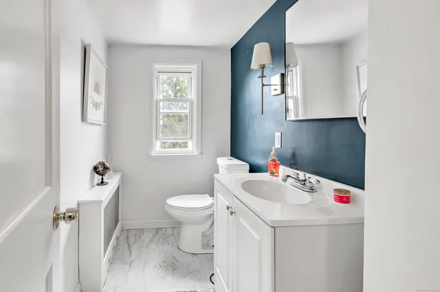 a bathroom with a sink toilet and mirror