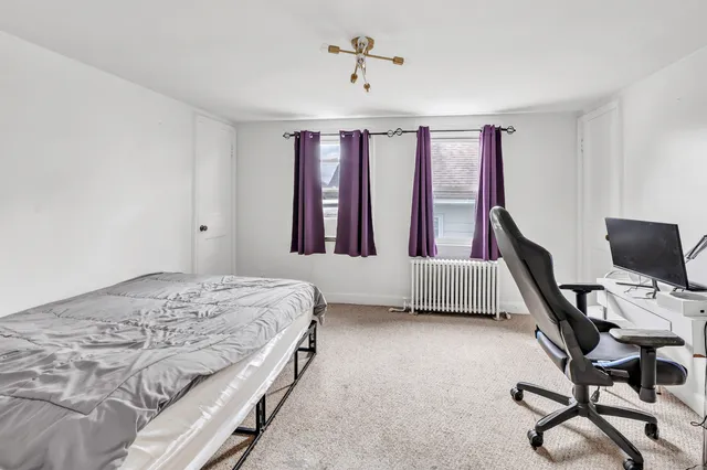 a bedroom with a bed chairs and a window