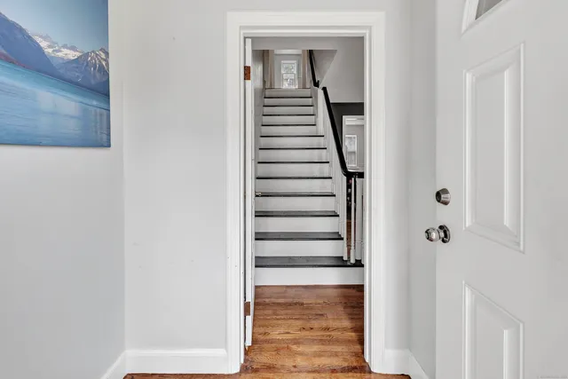 a view of a hallway with wooden floor and staircase