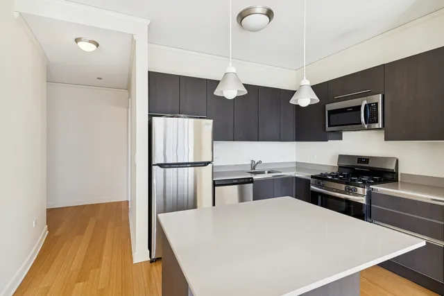 a kitchen with stainless steel appliances a stove a refrigerator and a microwave