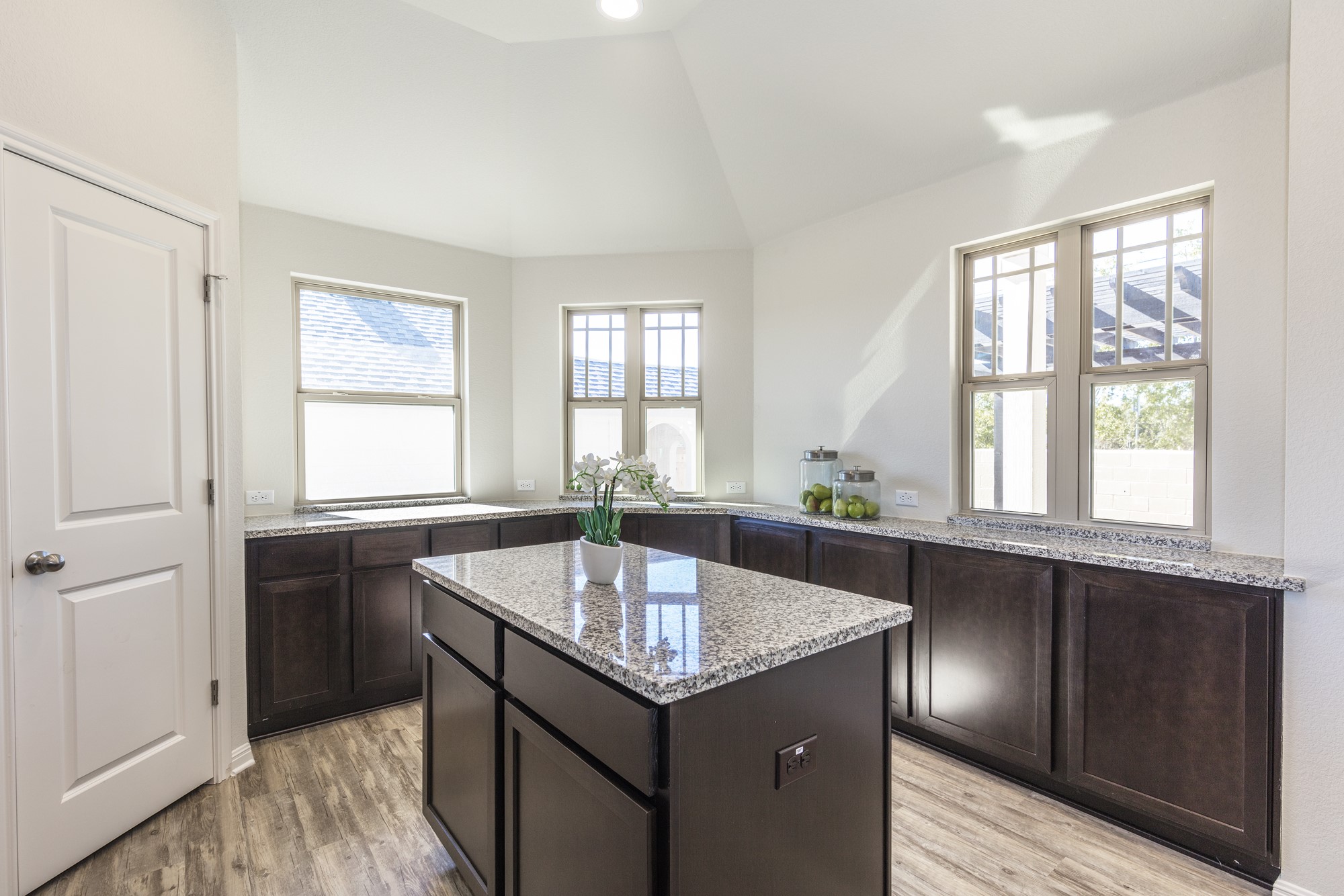 2725 Hopi Path Leander, TX 78641 - Photo 21 of 30 A well-lit kitchen featuring a central island with granite counters and rich cabinetry along the walls.