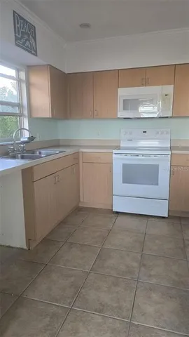 a kitchen with a stove sink and cabinets