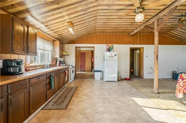 a view of a kitchen with refrigerator and a sink