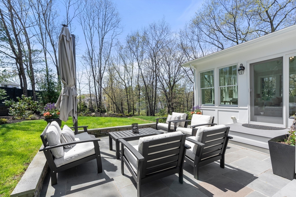 69 Royalston Road Wellesley, MA 02481 - Photo 28 of 31 a view of a patio with couches and a table and chairs with plants and trees