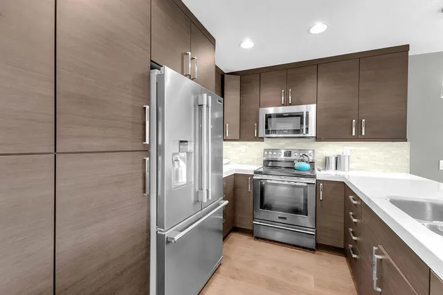 a kitchen with kitchen island a sink stainless steel appliances and cabinets