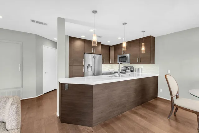 a view of kitchen island wooden cabinets and stainless steel appliances