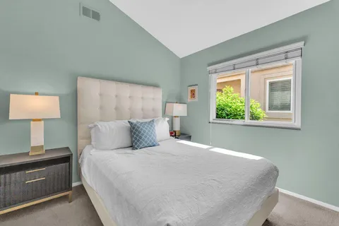 a large bed sitting in a bedroom next to a window