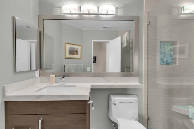 a bathroom with a sink a toilet and a mirror