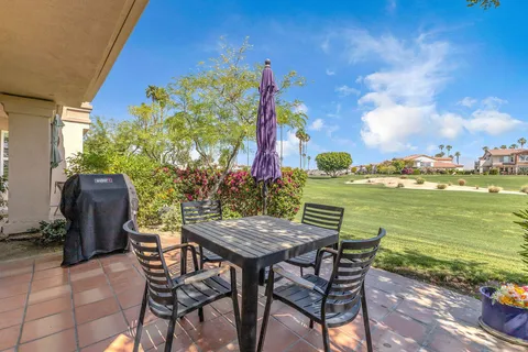a view of a chairs and table in patio with a lake view